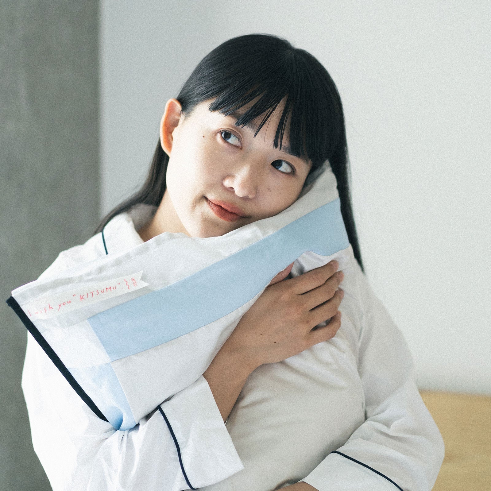 枕カバー KITSUMU フジ｜富士山モチーフのパッチワークを抱えた様子